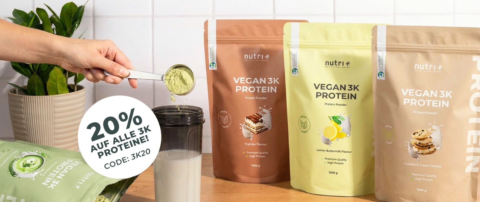 Vegan 3K Protein-Pulver in drei Geschmacksrichtungen, Shaker und Rabattangebot auf der Arbeitsplatte.